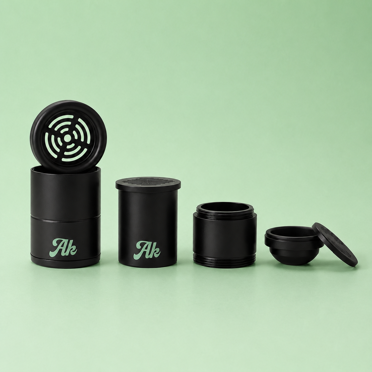 Set of black aluminium components of akcomplice & co’s personal air filter on a green background