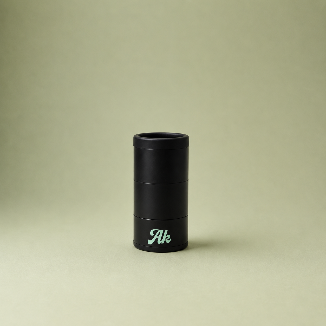 Black cylindrical object with 'Ak' branding on a beige background