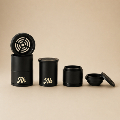 Set of black cylindrical containers with 'Ak' branding on a beige background
