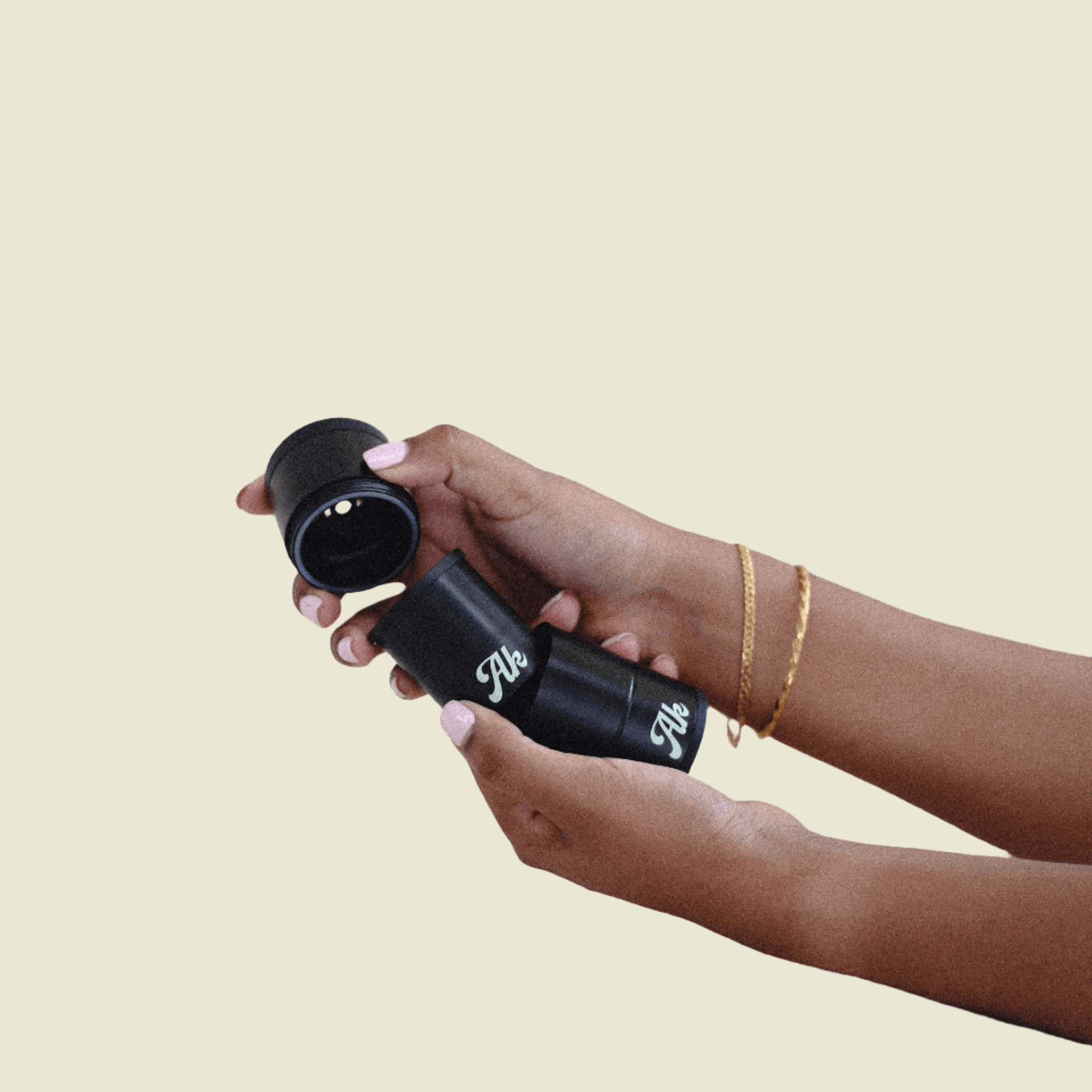 Hands holding Akcomplice & Co's black personal air filter for discreet plant-based medicine use